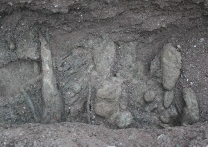 Trench excavation with wood debris and mudballs in coarse sand. Not preferential alignment.